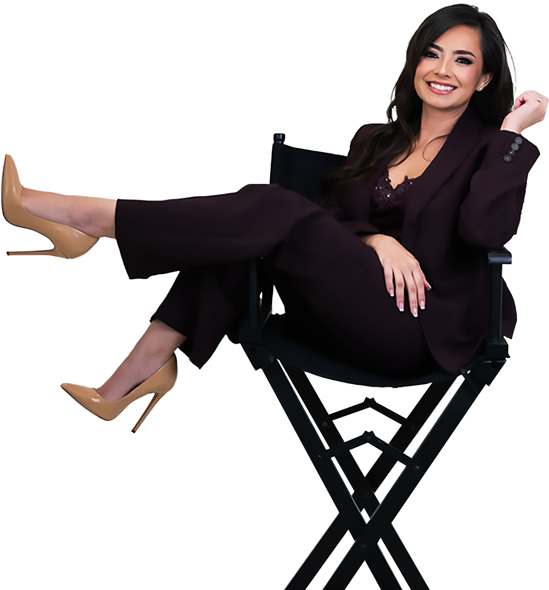 Andrea Ocampo seated in a director's chair wearing a deep burgundy suit